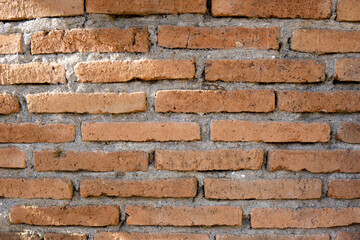 Red brick wall texture background with weathered bricks, cement joints, and an aged, grungy appearance
