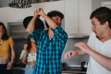 Obraz premium Group of friends in a kitchen engaging in a playful game, using a pan as a part of the fun, with expressions of surprise and laughter.