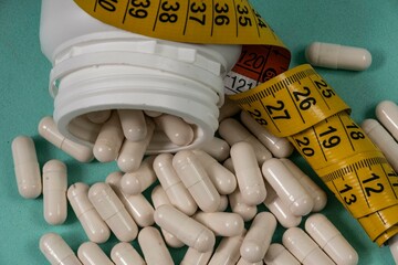 bottle of pills, some of which spilled onto a light blue surface