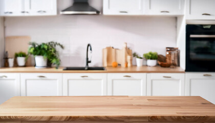 Blurred view of modern kitchen with white furniture with wooden table