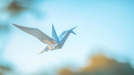 A lowangle shot of an origami crane suspended in midair by invisible strings
