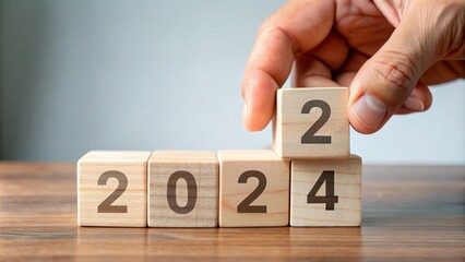 A hand flips a wooden block from 2024 to 2025, symbolizing a fresh start, new goals, and strategic planning for the upcoming year.