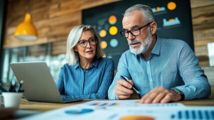 Senior Business Partners Collaborating on Laptop in Home Office
