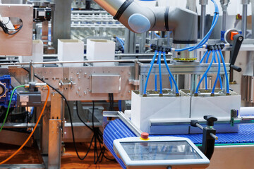 technology automated robotic arm handling product packaging to cardboard boxes on a conveyor belt in modern industrial production line in factory. innovation logistic and production line system