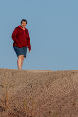 Plus size overweight woman standing on sandstone hill. Middle age Active Lifestyle