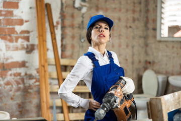 Portrait of a female builder with an industrial puncher in her hands