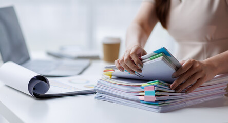 Adult businesswoman or auditor examining documents and laptop. financial document reports,...