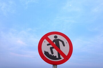 No climbing on dangerous rocks sign with close up view.