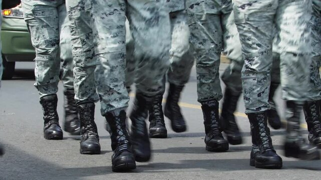 group of male soldiers marching at a military parade. Close up black military boots. Gray camouflage military suit. war concept