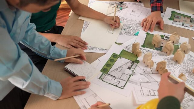 Architect and safety engineer discussion about building construction use blueprint on table with architectural document, measurement tool and wooden block scatter around at modern office. Delineation.