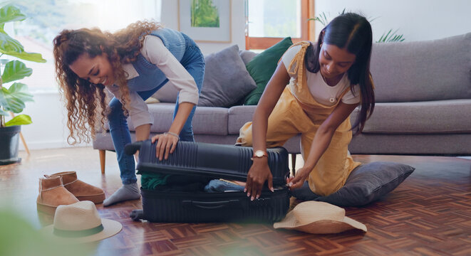 Packing, smile and suitcase with lesbian couple in living room of home, getting ready for holiday or vacation. Love, luggage and travel with LGBT women in apartment together for break or trip - Powered by Adobe