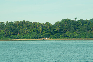 As the mountains stand tall in the port, the fishermen's boat sets sail.