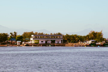 Obraz premium As the mountains stand tall in the port, the fishermen's boat sets sail.