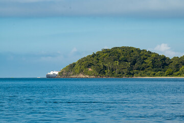 As the mountains stand tall in the port, the fishermen's boat sets sail.