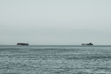 As the mountains stand tall in the port, the fishermen's boat sets sail.