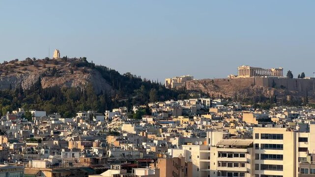 Lofos Philapappou and Acropolis in Athens seen in the distance, afternoon.
