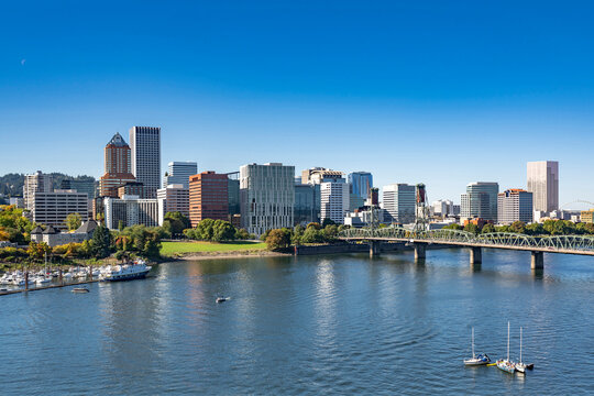 Portland Downtown with office and residential high-rise buildings on the waterfront of the Willamette River with a marina and an arched drawbridge over the river