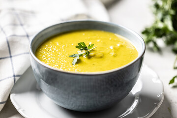 Healthy creamy vegetable soup in a blue bowl.