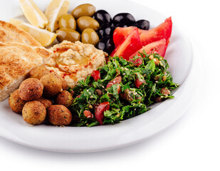 Plate presenting a colorful and tasty middle eastern mezze platter with various dips and salads