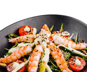 Fresh salad with shrimps, avocado and cherry tomatoes on black plate