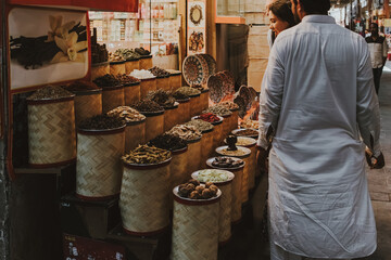 Dubai, UAE - January 6, 2020: People exploring a spice stall in Dubai's traditional souq