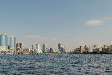 Fototapeta premium Dubai, UAE - January 6, 2020: Modern skyscrapers and traditional architecture along Dubai Creek waterfront