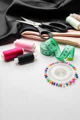 Crafting essentials for sewing projects displayed on a table with fabric, threads, and tools
