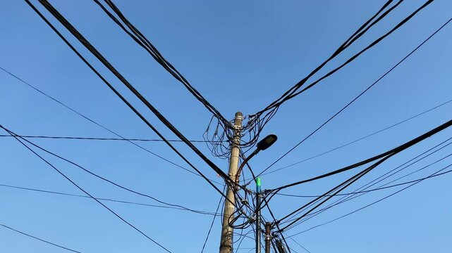 Electric cables and street light poles with blue sky background