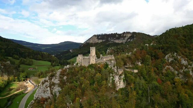 Pan drone shot of Neu-Falkenstein ruins in the canton of Soleure in Switzerland in the fall season in the village of Balsthal.