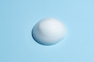 Face cleansing mousse of shampoo foam sample on blue background