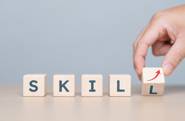 SKILL words on wooden blocks with trend arrow-up graph icons. Upskill training, knowledge and education, learning. Up-skilling, Re-skilling. Upskilling and personal ability development concept.