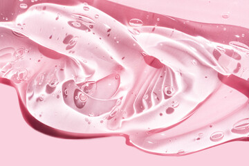 Liquid gel abstract cosmetic in pink background. Smear of transparent moisturizing product