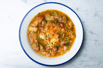 Castilian soup with vegetables, bread croutons and egg. Top view table with  decorations.