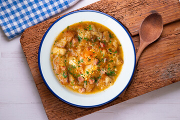 Castilian soup with vegetables, bread croutons and egg. Top view table with  decorations.