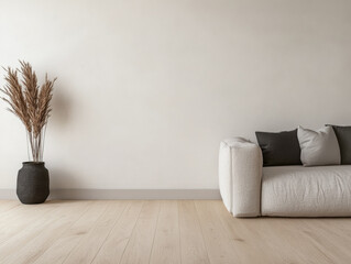 A minimalist living room featuring a comfortable light sofa, decorative cushions, and a potted plant in a serene and bright setting