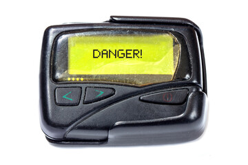 Old pager on a white background. Text Danger on the screen
