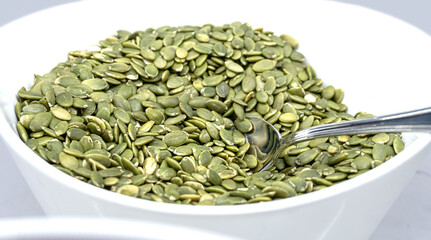 Shelled Pumpkin Seeds on a White Plate - Side View