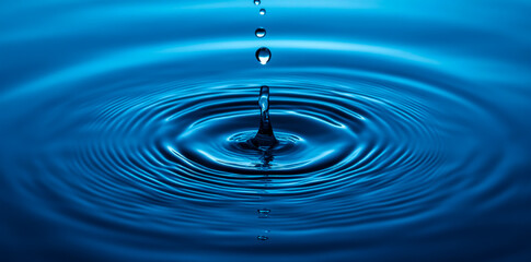 Water splash with a blue-colored background, water drops, and ripples on the surface of clean, fresh water