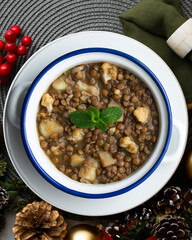 Lentil stew with potatoes, traditional Spanish tapa. Top view table with Christmas decorations.