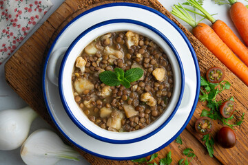 Lentil stew with potatoes, traditional Spanish tapa. Top view table with  decorations.