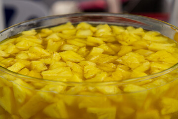 A bowl of pineapple chunks in a glass bowl