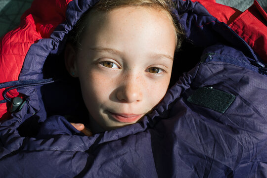 child wrapped up in a sleeping bag whilst camping
