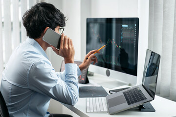 Businessman investor working with smartphone and computer analyzing graph stock market trading planning with chart data financial investment planning