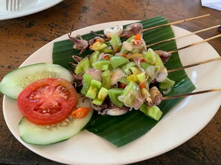 Balinese Grilled Squid with Dabu Dabu Chili Sauce. Spicy Indonesian condiment sambal made of tomato, garlic and shallot with lemon basil