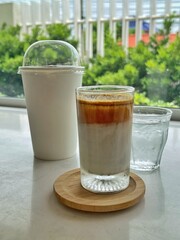 Dirty Coffee - A glass of espresso shot mixed with cold fresh milk on blurred background and copy space, Perfect drink for summer time.