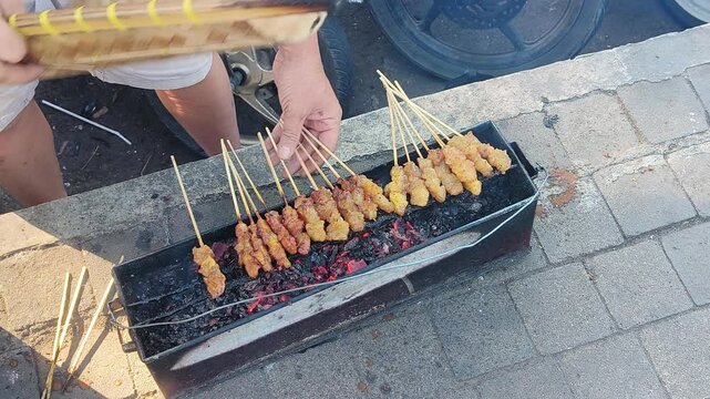 close up on grilling sate jando or fat satay, is indonesian traditional food made from cow fat
