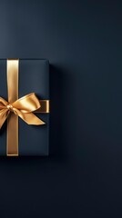 top view of black gift box with a golden ribbon on black background