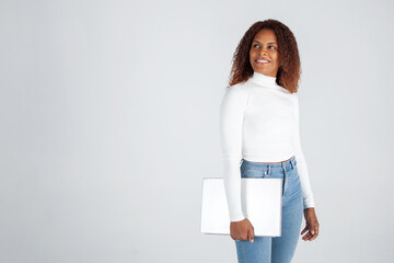 Chica afroamericana con portátil en mano. Estudiante universitaria sonriendo. Publicidad de...