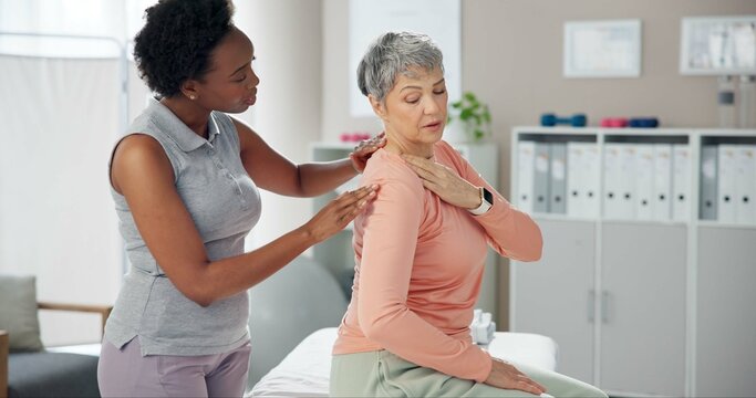 Woman, physiotherapist and patient with shoulder pain for medical consultation or injury at clinic. Female person, orthopedic and senior client with sore muscle, ache or tension at private practice - Powered by Adobe