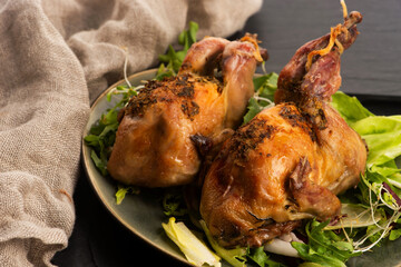 Baked tasty quails on ceramics plate with salad